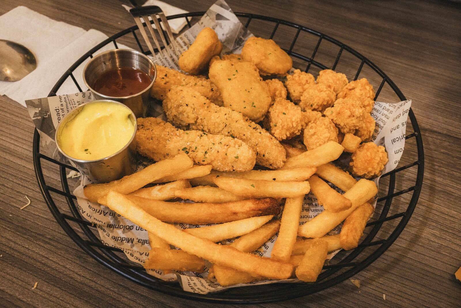 Basket of jumbo chicken tenders with fries and dipping sauces